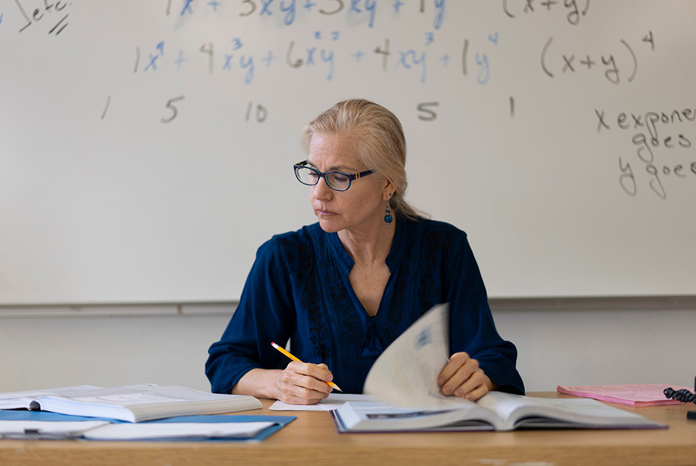 Teacher marking exams at desk